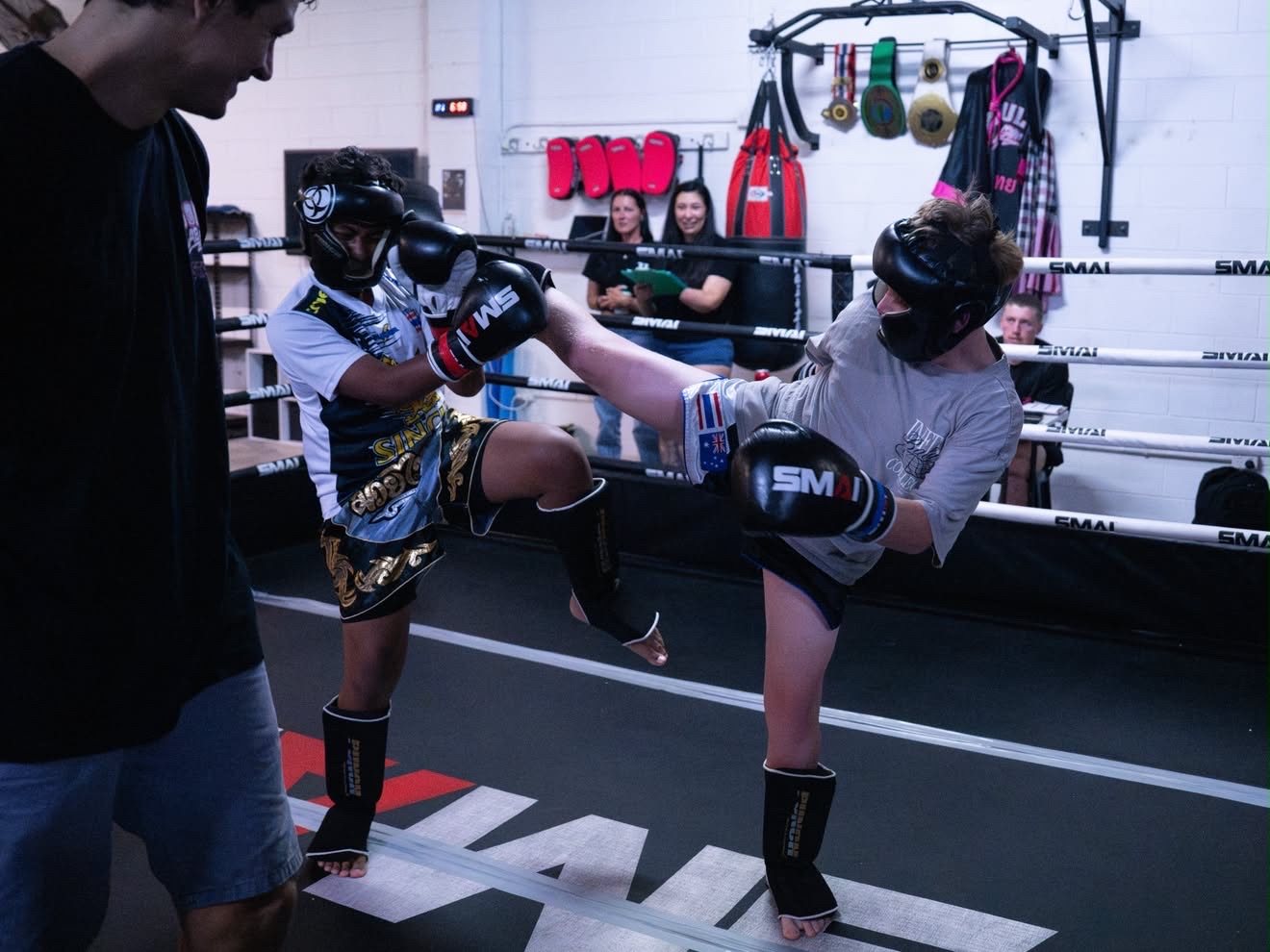 Teen fighters exchanging kicks in headgear