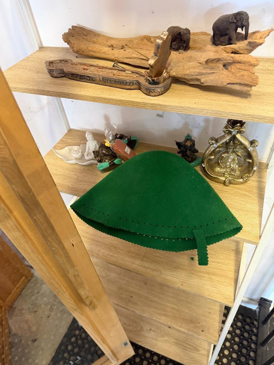 Recovery studio accessories shelf including traditional green sauna hat, Ganesha statue and other decor